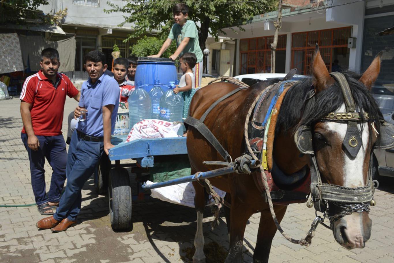 At arabasıyla evlerine içme suyu taşıyorlar